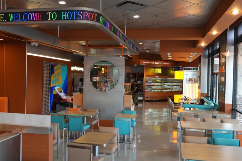 The Hot Spot 61 dining room with teal chairs and a scrolling welcome sign